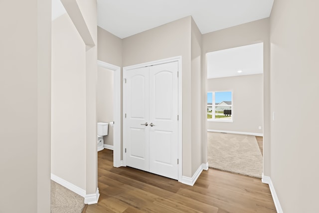 corridor featuring baseboards and wood finished floors