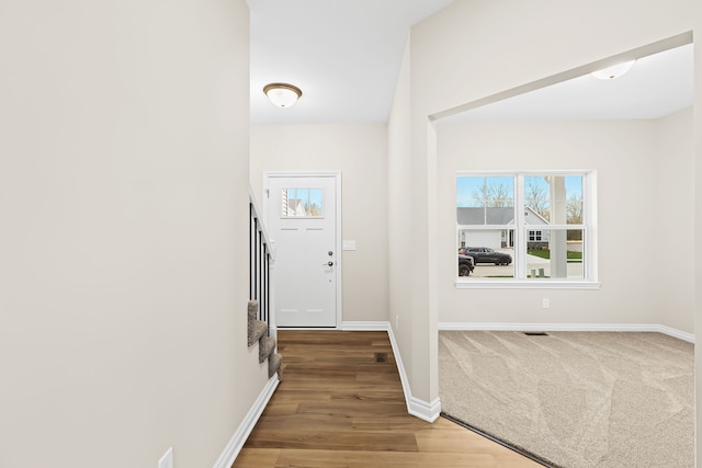 entryway with stairs, baseboards, and wood finished floors