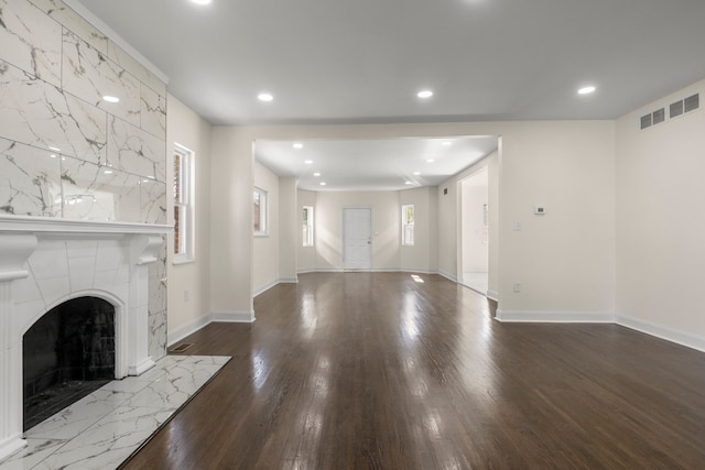 unfurnished living room with dark wood-type flooring and a large fireplace