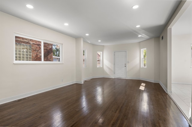 unfurnished room featuring dark wood-type flooring and a wealth of natural light