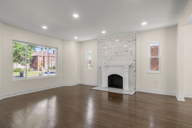 unfurnished living room with a high end fireplace and dark hardwood / wood-style flooring