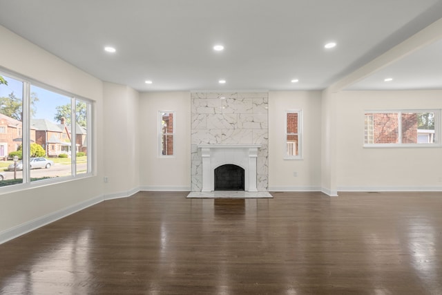 unfurnished living room with a large fireplace and dark hardwood / wood-style flooring