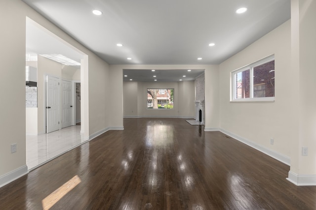 unfurnished living room featuring a fireplace and dark hardwood / wood-style floors