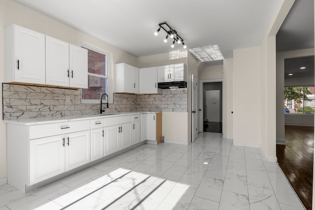 kitchen with sink, white cabinetry, and tasteful backsplash