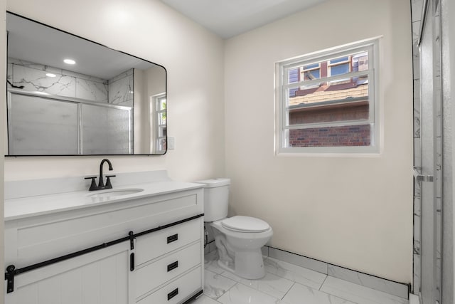 bathroom featuring an enclosed shower, vanity, plenty of natural light, and toilet