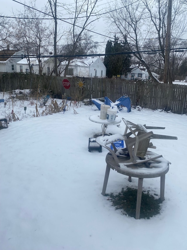 yard layered in snow featuring fence