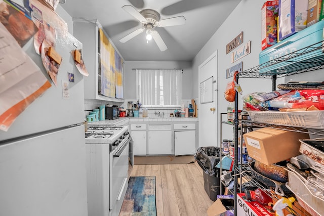 kitchen featuring white appliances, light wood-type flooring, ceiling fan, white cabinets, and tasteful backsplash