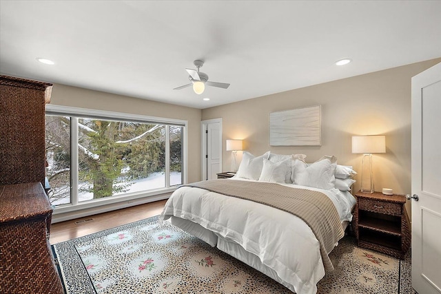 bedroom featuring multiple windows, hardwood / wood-style flooring, and ceiling fan