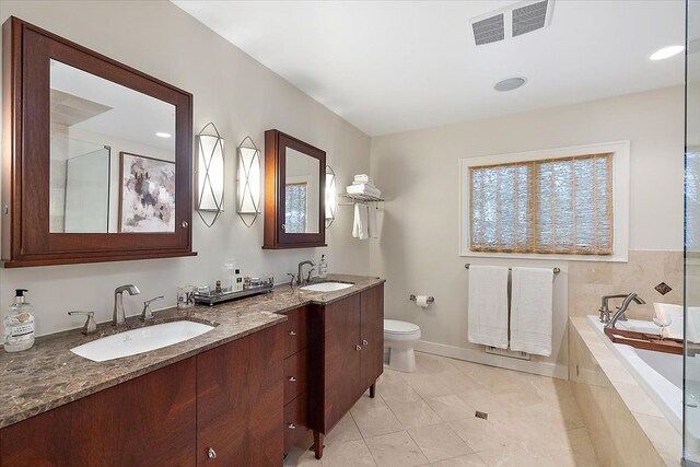 bathroom featuring vanity, tile patterned floors, tiled bath, and toilet