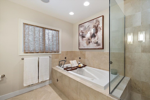 bathroom featuring tile patterned flooring and tiled tub