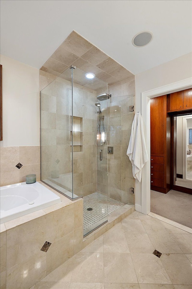 bathroom featuring separate shower and tub