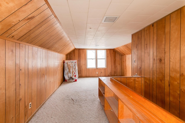 bonus room with light carpet, lofted ceiling, and wood walls