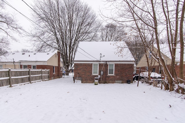 view of snow covered rear of property