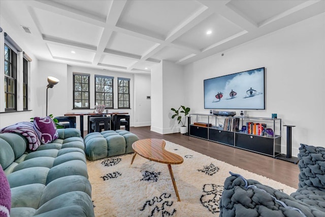 living area featuring baseboards, coffered ceiling, wood finished floors, and beamed ceiling