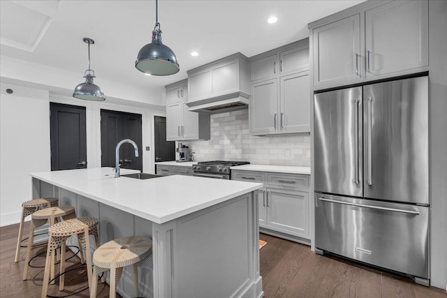 kitchen with tasteful backsplash, appliances with stainless steel finishes, dark wood-type flooring, gray cabinets, and a sink