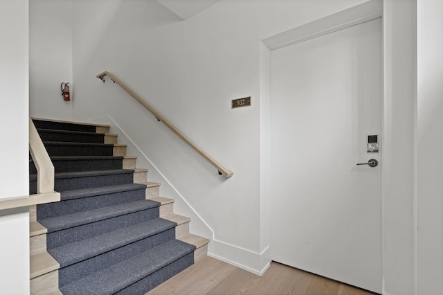 staircase with baseboards and wood finished floors