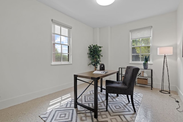 home office with baseboards and a healthy amount of sunlight