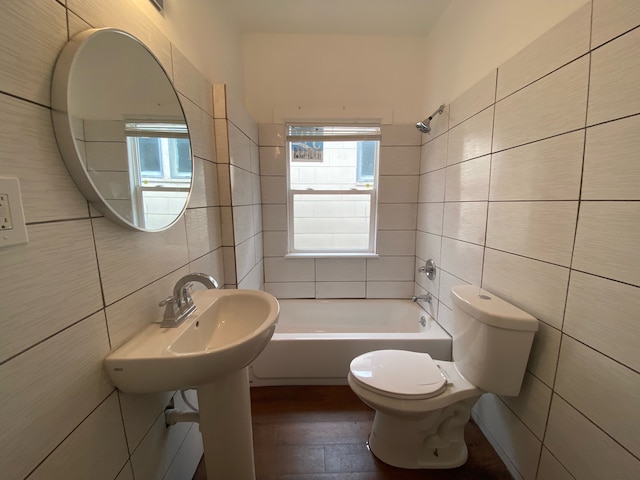 bathroom featuring  shower combination, tile walls, and toilet