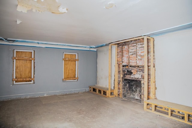 unfurnished living room with concrete flooring and a fireplace