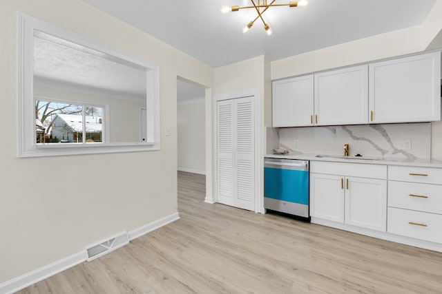 kitchen with white cabinetry, tasteful backsplash, and dishwasher