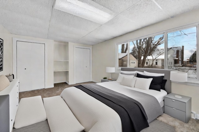 bedroom featuring carpet flooring and multiple closets