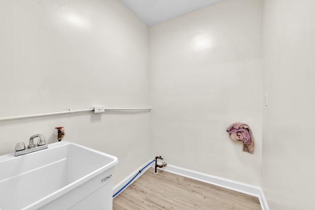 laundry area featuring light hardwood / wood-style flooring and sink