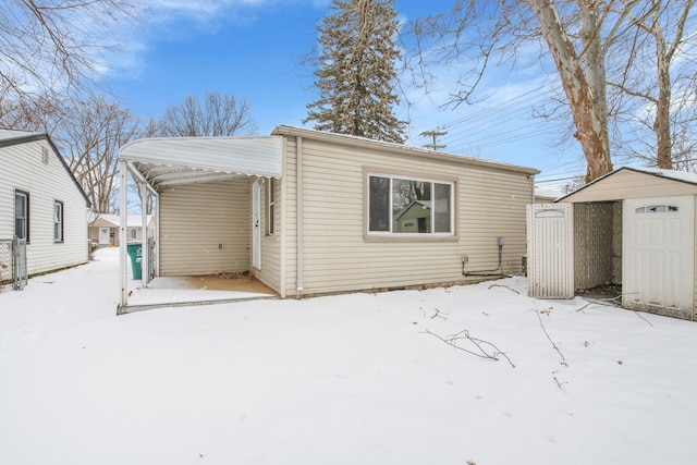 view of front of property with a carport and a storage unit