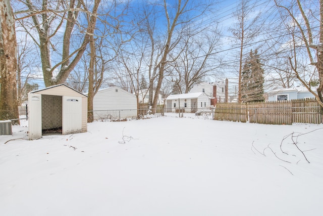 yard layered in snow with a shed