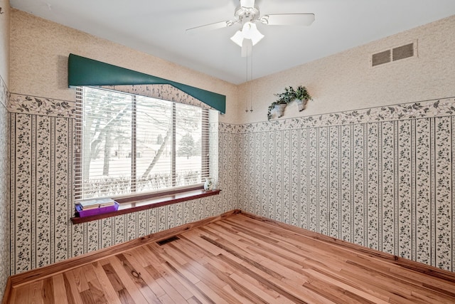 spare room with hardwood / wood-style floors and ceiling fan