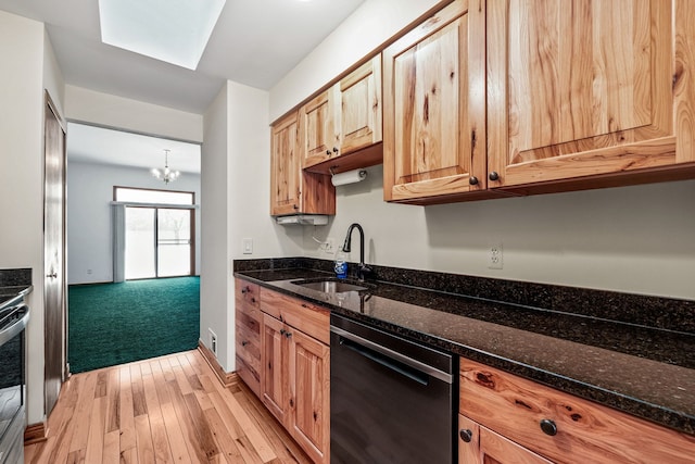 kitchen featuring sink, a notable chandelier, dark stone countertops, and black dishwasher