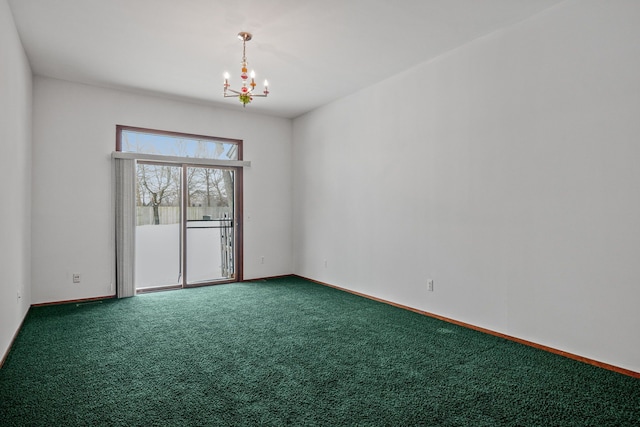 spare room featuring carpet floors and a notable chandelier