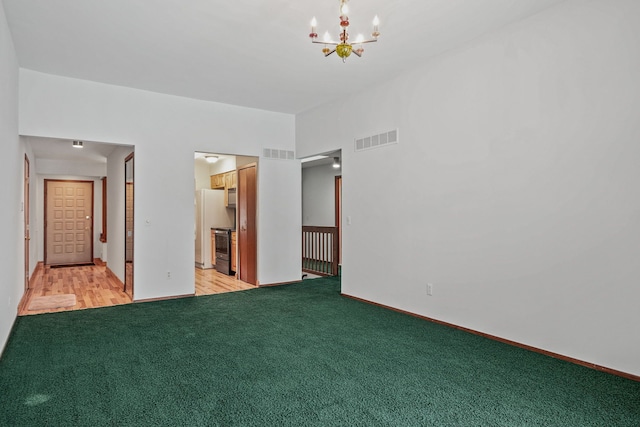 empty room with a notable chandelier and light carpet