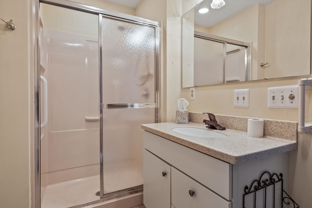 bathroom with a shower with door and vanity