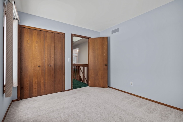 unfurnished bedroom with a closet and carpet floors