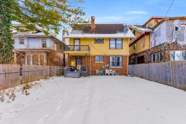 snow covered property with a balcony