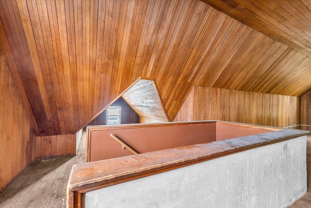 additional living space with wood walls, vaulted ceiling, and wood ceiling