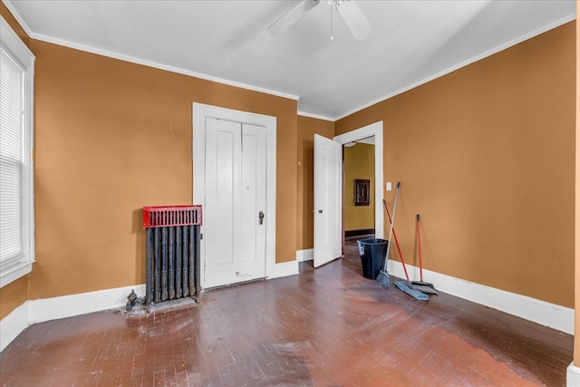 unfurnished room with ceiling fan, ornamental molding, radiator, and wood-type flooring