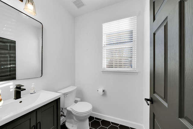 bathroom featuring tile patterned flooring, vanity, and toilet