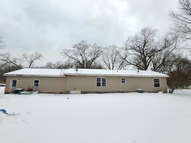 view of snow covered rear of property