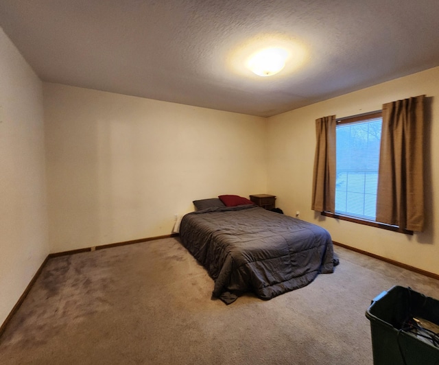 bedroom with a textured ceiling and light colored carpet