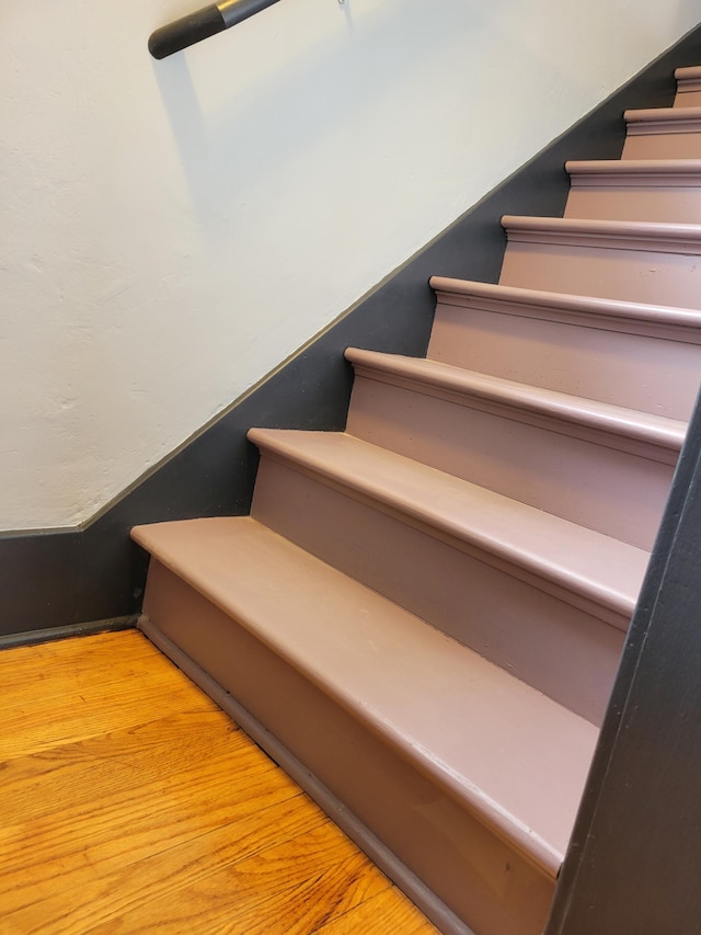 stairs featuring hardwood / wood-style floors