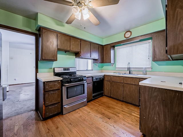 kitchen with gas stove, dishwasher, dark brown cabinets, and sink