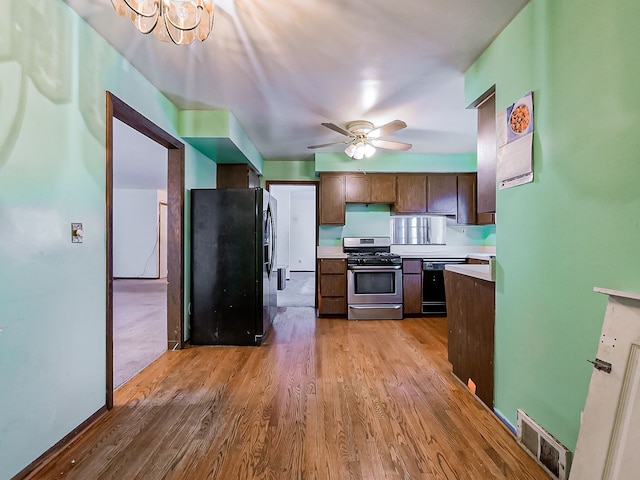 kitchen featuring black appliances, ceiling fan with notable chandelier, and light hardwood / wood-style flooring