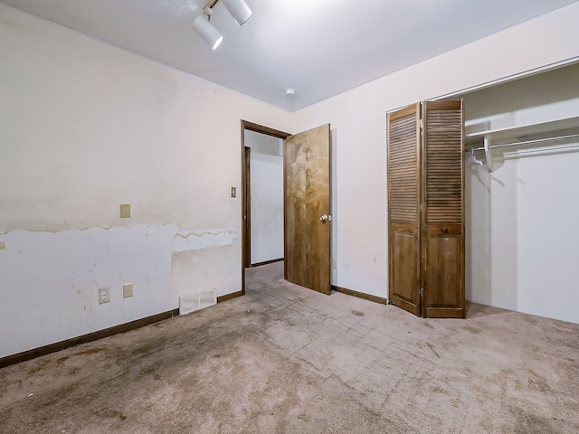 unfurnished bedroom featuring a closet and light colored carpet