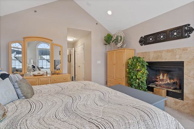 bedroom featuring a tile fireplace and high vaulted ceiling