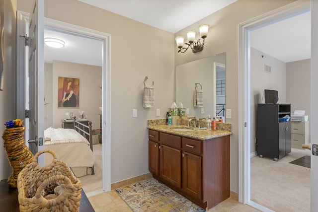 bathroom featuring an inviting chandelier, tile patterned floors, and vanity