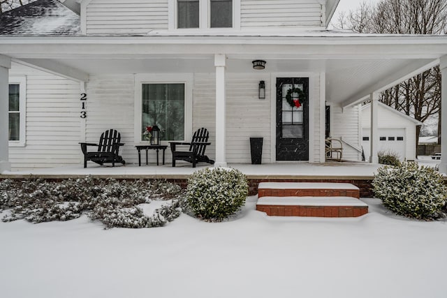 snow covered property entrance with a porch