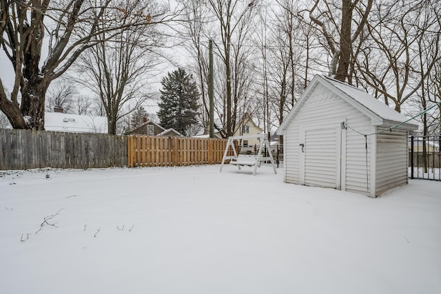 yard covered in snow with a storage shed