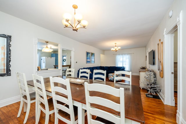 dining space featuring dark hardwood / wood-style flooring and an inviting chandelier