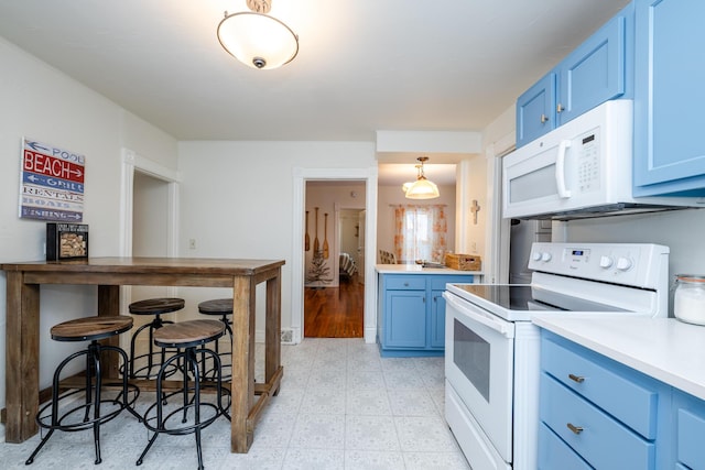 kitchen with blue cabinetry, decorative light fixtures, and white appliances